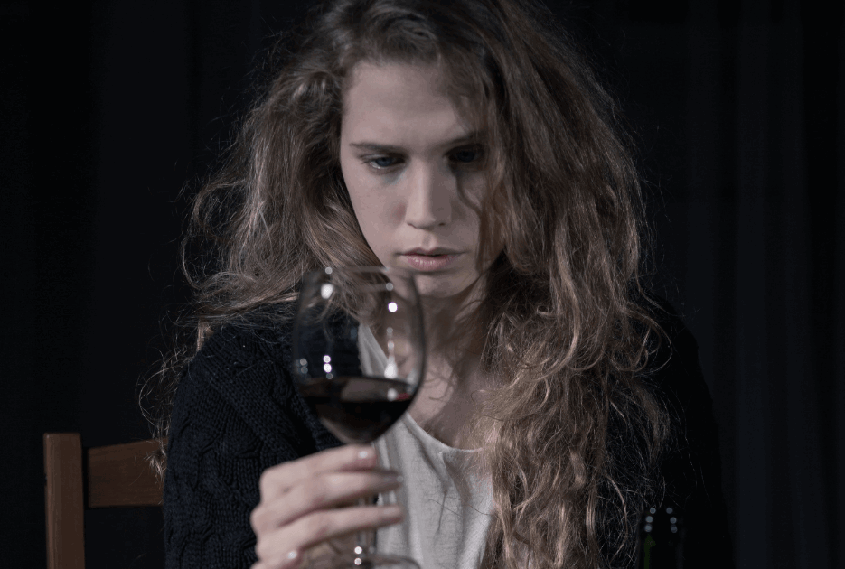 Ung kvinde med et glas vin i hånden